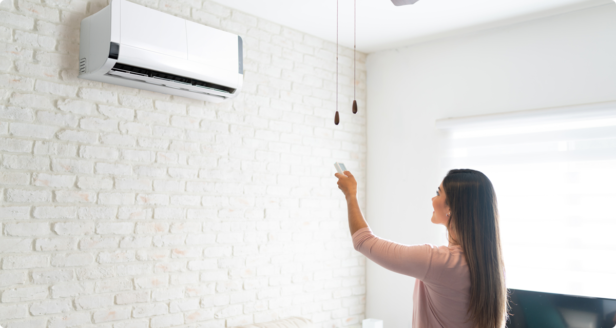 Woman using remote to control mini split unit